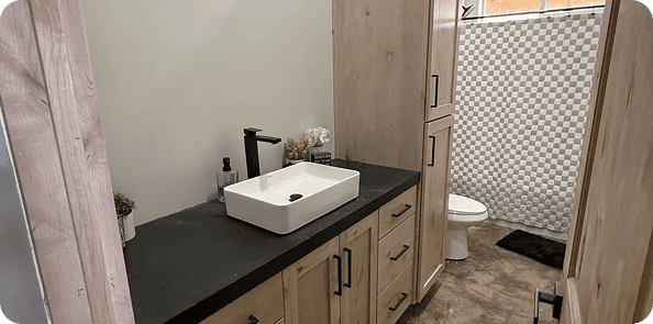 Modern bathroom with wooden cabinets and sink.