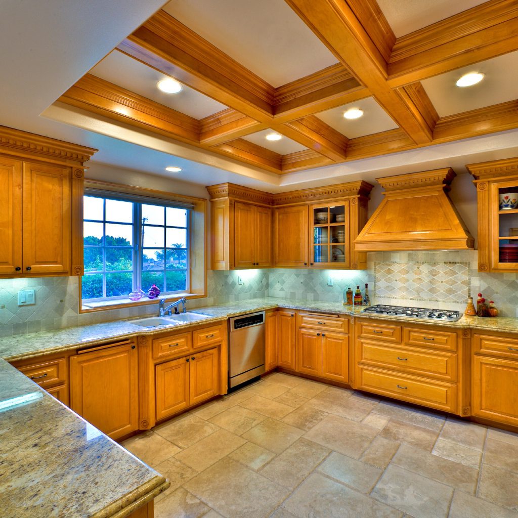 Wooden kitchen with modern appliances and lighting.